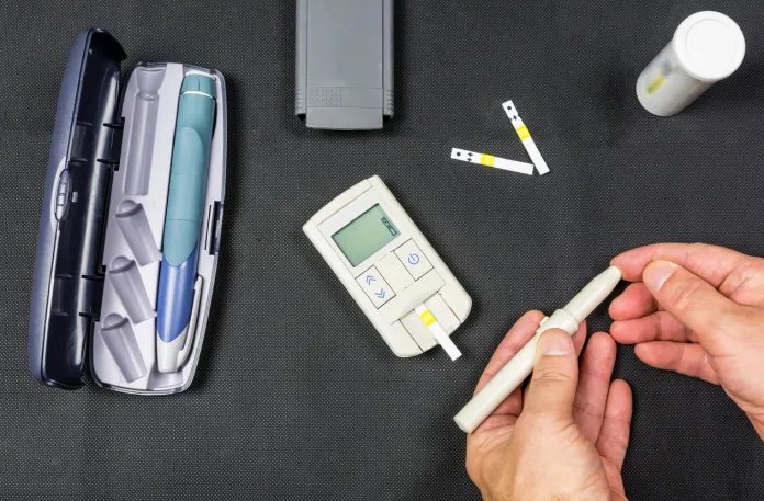 Una persona che controlla il livello di zucchero nel sangue, il che può essere utile per gestire malattie come il diabete